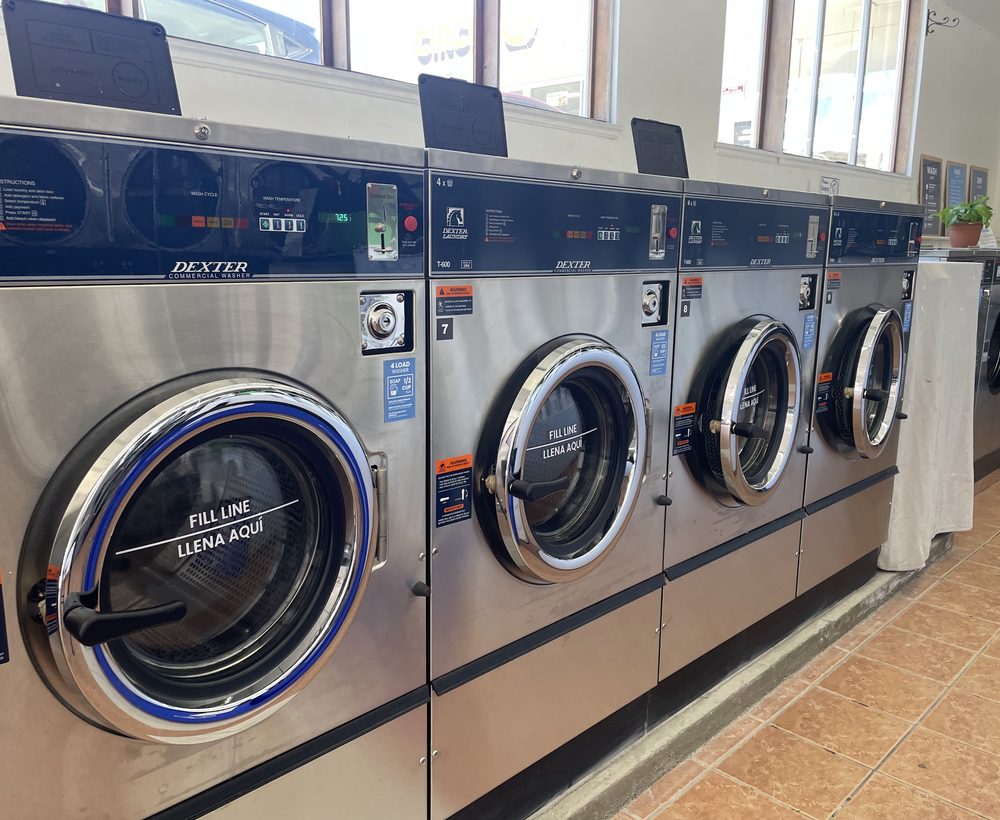A row of large commercial washing machines at The Laundry Hub on Mission Street in San Francisco