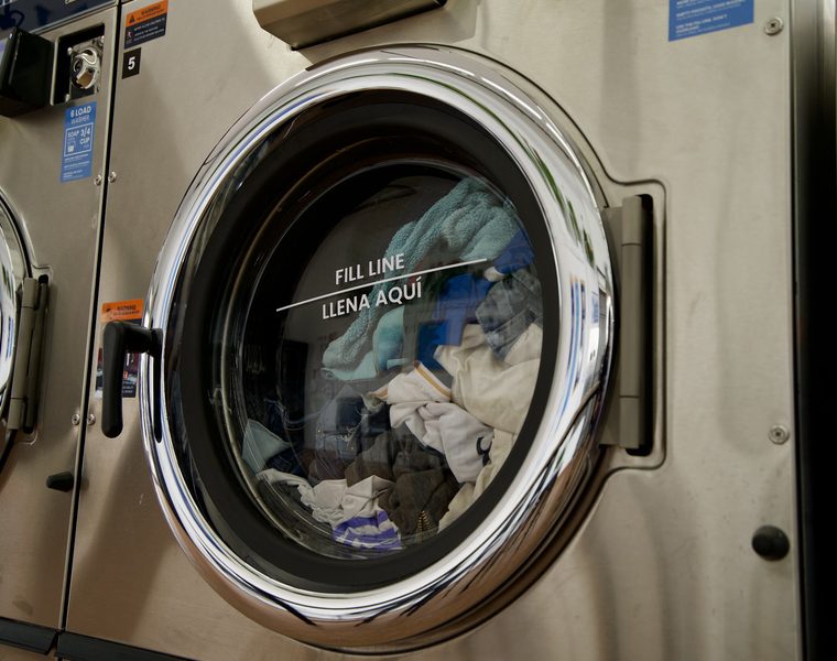 Business linen washing on its own inside a commercial machine at The Laundry Hub SF