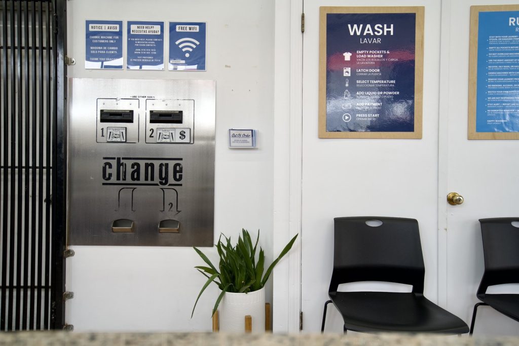 Coin change machine and free wifi notice beside the seating area at The Laundry Hub SF